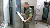 Deutscher Soldat liest Daten aus einem Sterilisator aus