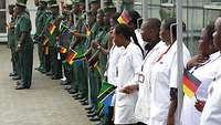 Afrikanische Soldaten und medizinische Fachkräfte mit deutschen und tansanischen Flaggen