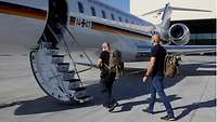 Zwei Männer steigen in ein Flugzeug