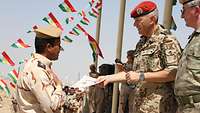 Deutscher Soldat überreicht einem kurdischen Soldaten eine Ausbildungsurkunde