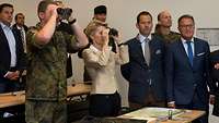 Von der Leyen schaut gemeinsam mit Soldaten durch Ferngläser