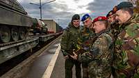 Soldaten unterschiedlicher Nationen besprechen den Umschlag von Fahrzeugen am LogHub in Pfungstadt.