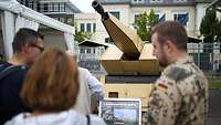 Besucher vor Exponat Mantis
