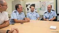 Vier Soldaten sitzen zusammen an einem Tisch