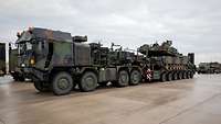 Ein amerikanischer Panzer vom Typ M1 Abrams wird auf einen Schwerlasttransporter vom Typ Mammut verladen