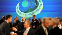 Personen im Gespräch vor dem Logo des NATO-Russland-Rates