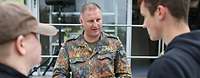 Soldat im Gespräch mit Zivilisten am Bundeswehr Karrieretruck