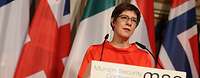 Kramp-Karrenbauer spricht am Rednerpult auf der Münchner Sicherheitskonferenz, Flaggen im Hintergrund