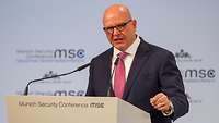 Ein Mann spricht am Rednerpult ins Mikrofon.