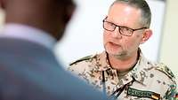 Deutscher Soldat im Gespräch mit einem Einheimischen 