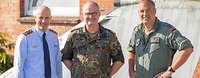 Drei Soldaten stehen vor einem Gebäude
