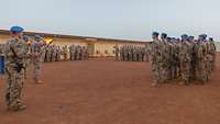 Mehrere Soldaten stehen in einer Formation auf einem Platz