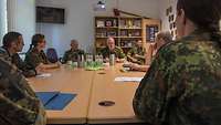 Mehrere Soldaten sitzen an einem Konferenztisch