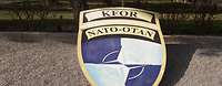 Wappen KFOR vor einem Gebäude