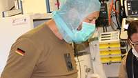 Soldat mit Mundschutz und Haarnetz