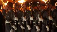 Angetretene Soldaten mit Fackeln