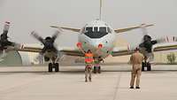 Ein Soldat weist ein Flugzeug vom Typ P-3C Orion nach der Landung ein