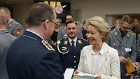 Von der Leyen überreicht einem Soldaten eine Medaille und ein Buch