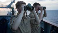 Zwei Soldaten mit Fernglas bei der Seeraumüberwachung