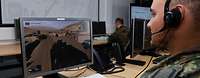 Ein Soldat der Bundeswehr sitzt mit Headset an einem Computer