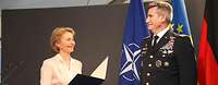 Von der Leyen überreicht einem Soldaten eine Urkundenmappe