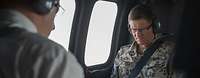 Ein Bundeswehrsoldat sitzt im Hubschrauber und macht sich Notizen