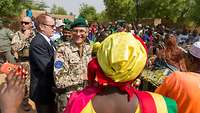 Ein Bundeswehrsoldat zwischen tanzenden malischen Dorfbewohnern