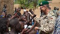 Ein Bundeswehrsoldat umringt von malischen Kindern