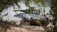 Ein Schützenpanzer Puma fährt durch das Gelände und wirbelt Staub auf