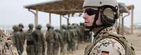 Ein deutscher Soldat beobachtet afghanische Soldaten, die in einer Schlange stehen
