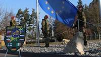 Soldaten salutieren beim Einholen der EU-Flagge
