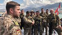 Ein deutscher Soldat spicht an Oberdeck eines Schiffes zu libanesischen Soldaten