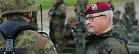Generalinspekteur Zorn im Gespräch mit einem Soldaten, im Hintergrund Soldaten auf einer Schwimmbrücke