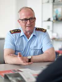 Generalinspekteur Zorn spricht mit einem Mann, der ihm gegenüber sitzt