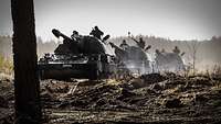 Drei Panzerhaubitzen 2000 fahren hintereinander im Gelände.
