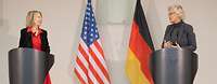 Ministerin Lambrecht und Amy Gutmann stehen an Rednerpulten. Hinter ihnen stehen die Flaggen von Deutschland und den USA.