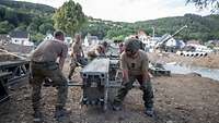 Soldaten tragen ein Teil einer Behelfsbrücke.