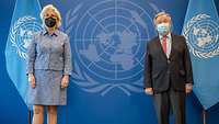 Minister Lambrecht and Antonio Guterres stand side by side in front of the UN logo and flags.