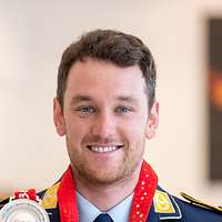 Der Athlet Julian Rauchfuss hält seine Silber-Medaille hoch.