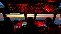 Das Innere eines Cockpits von dem Flugzeugtyp P3-C Orion mit drei Crewmitgliedern.