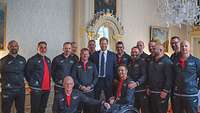 Prinz Harry steht inmitten einer Gruppe von Sportlern