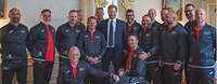 Prinz Harry steht inmitten einer Gruppe von Sportlern
