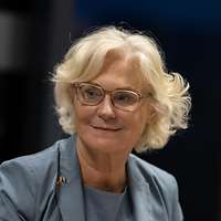Ministerin Lambrecht sitzt an einem Tisch und lächelt