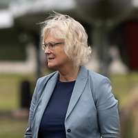 Ministerin Lambrecht spricht mit einem deutschen Soldaten. Im Hintergrund steht ein Kampfflugzeug.