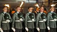 Angetretene Soldaten mit vor der Brust gehaltenem Helm in der Dämmerung vor Reichstagsgebäude