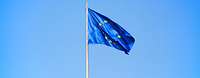 Die Europaflagge weht im Wind vor hellblauem Himmel.