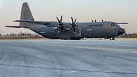 Ein Transportflugzeug vom Typ Hercules steht auf der Landebahn.