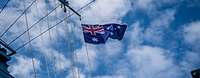Eine wehende australische Flagge, im Hintergrund blauer, leicht bewölkter Himmel