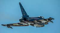 Aus der Froschperspektive ist ein fliegender Eurofighter mit Speziallackierung zu sehen.