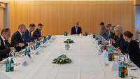 Verteidigungsministerin Lambrecht sitzt mit dem ukrainischen Ministerpräsident und weiteren Personen an einem Tisch.